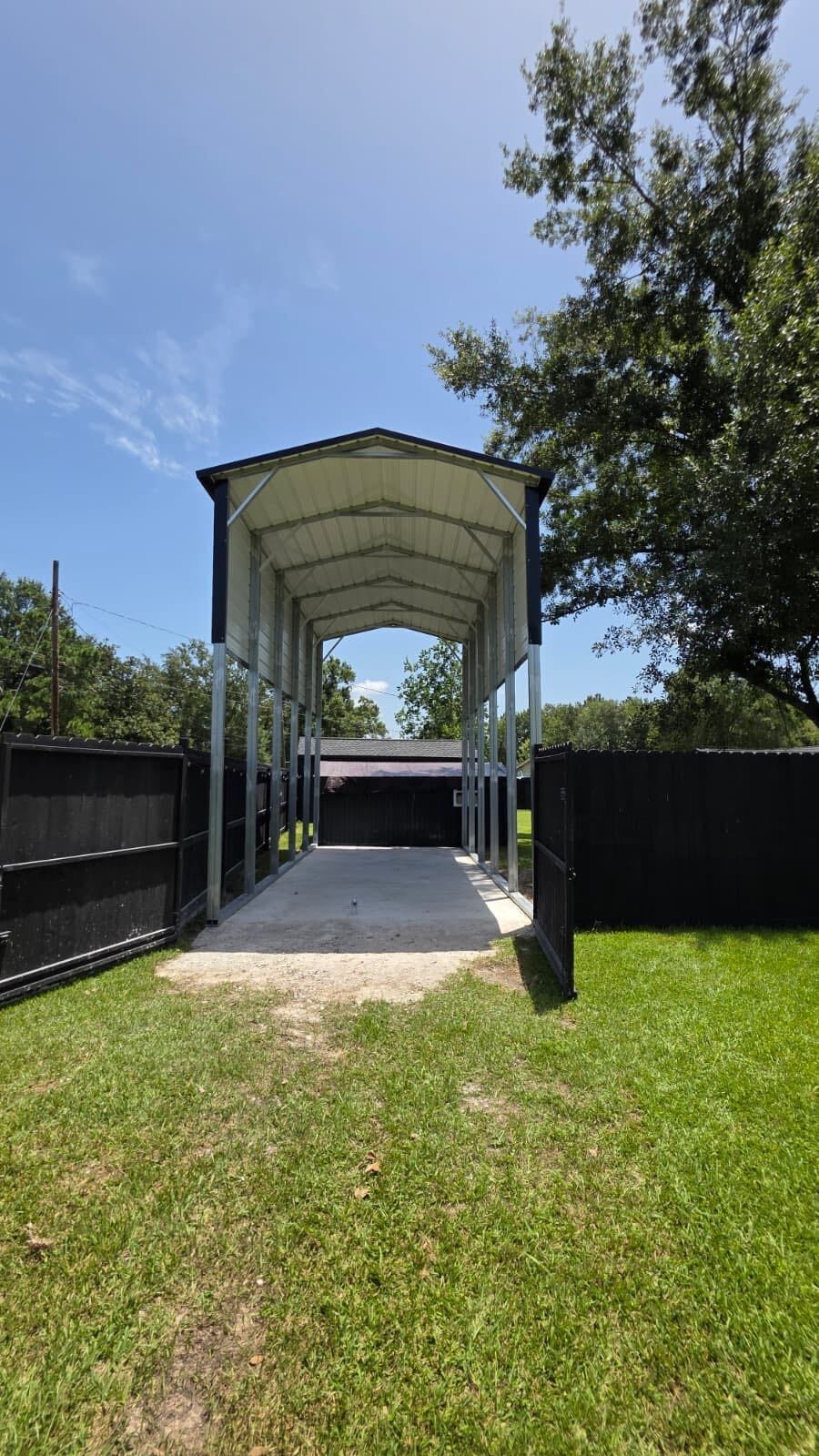 Tall steel RV cover on galvanized tube posts over a concrete pad — a recent Forge Steel job